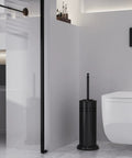 Heavy Duty Toilet Plunger With Sturdy Powder Coated Iron Holder For Modern Bathrooms And Beast Mode Suction Rubber Cup That Kicks Nasty Clogs To The Curb In Pure Black Finish displayed beside a modern toilet.