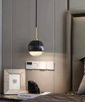 LTNANJE Modern LED Small Natural Stone Pendant Light Fixture Mid Century Marble Hanging Lamp in black over bedside table.