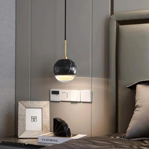 LTNANJE Modern LED Small Natural Stone Pendant Light Fixture Mid Century Marble Hanging Lamp in black over bedside table.
