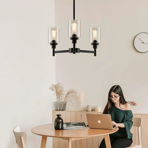 Industrial Glass Cylinder Pendant Chandelier in Black, 6 Light Farmhouse Vibe for Dining Room, shown above a wooden table