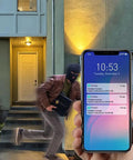 Hand holding phone displaying alerts from Outdoor WiFi PTZ Security Cam 1080P Waterproof with AI Human Detection at night