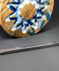 Side view of a 12-inch carbide woodturning tool with silver shank and cutting head on gray surface; blue resin wood behind