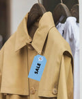 One Thousand Clear Three Inch Plastic Hang Tag Fasteners With Snap Lock Closure Secure Retail Clothing Label Pins No Fuss Durable Build For Jewelry Accessories And Hustle Shop Must Haves attached to a tan coat with a sale tag.