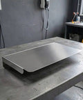 Kickass Stainless Steel EV Charger Protective Housing And Super Tough Weatherproof Outdoor Box Cover displaying flat surface on a workbench.