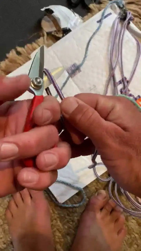 Hands using Five And A Half Inch Carbon Steel Shears Built For Kevlar, Dyneema, Spectra, Vectran, Nomex, Technora, And Other Heavy Duty High Tensile Materials to cut rope.