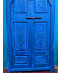 Blue Finish Hand Carved Barn Door With Custom Size Options, Double Or Single Panel, Sliding Or Hinged, Suitable For Interior Or Exterior Use, Front Door Style With Antique And Modern Flair, Made To Order with intricate carvings and vibrant blue color in focus.
