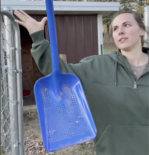 Person holding Sand Dipper Treasure Shovel Digger Sifter for beach cleanup and barn chores, rugged plastic scoop with steel rod.
