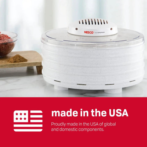 Snag This Badass Hella Reliable Four Tray Food Dehydrator For Herbs Fruit And Beef Jerky With Even Heat Distribution And Clear Top Viewing In Speckled White on a kitchen counter.