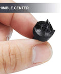 Black plastic thimble center for wood lathe turning, held between fingers.