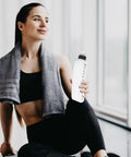 Person holding a 330ml Squeeze Water Bottle With Dust Proof Lid And Curved Design For Mountain Bikers On The Go