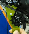 Rear Derailleur Adjuster and Chain Gap Gauge Tool for 12 Speed Eagle GX NX in use on a bike wheel with green ABS material