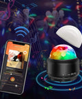 Lit Party Ready Mini Disco Ball with Bluetooth Speaker displaying LED lights next to smartphone app in dark party setting.