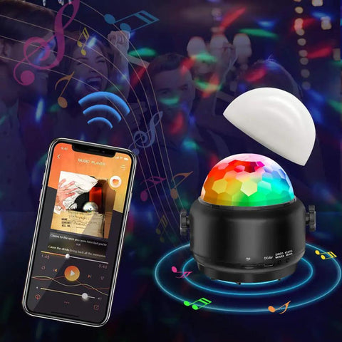 Lit Party Ready Mini Disco Ball with Bluetooth Speaker displaying LED lights next to smartphone app in dark party setting.