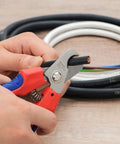 Straight Up Killer Electrician Wire Cutter in use, cutting through black copper wire with precision grip for clean cuts.