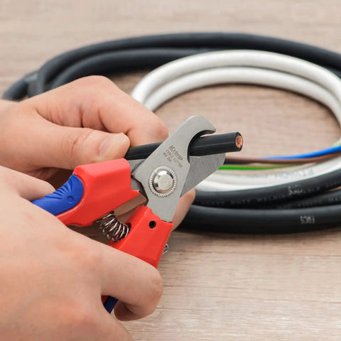 Straight Up Killer Electrician Wire Cutter in use, cutting through black copper wire with precision grip for clean cuts.