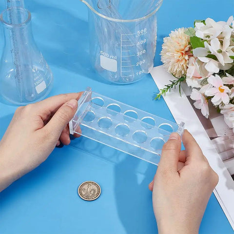 Hands holding Acrylic 10 Hole Test Tube Rack Display Stand For 5ml Tubes, Clear Lab Organizer With 0.67 Inch Holes on a blue surface