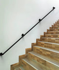 Badass Industrial Pipe Handrail For Indoor Or Outdoor Living Spaces Rock Solid Wall Mount Stair Rail in matte black on wooden stairs.