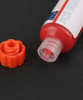 Flux Repair Kit With Light Curing Liquid No Clean Flux For PCB BGA Boards Includes Precision Needles And Flashlight For Quick Easy Solder Paste Fixes Like A Pro Today. Close-up of open red flux tube with orange cap on black background.