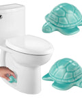 Heckin Adorable Ceramic Sea Turtle Toilet Bolt Caps Set Of 2 Snazzy Screw Cover next to toilet, teal ceramic turtles hiding bolts.