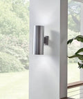 Outdoor Cylinder Wall Mount Sconce With Up And Down Lighting In White Finish illuminating a patio wall, showing 2 light design.