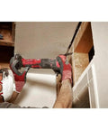 User operating Badass Brushless 12V Oscillating Multi Tool Full Setup Kit, cutting drywall in a confined space.