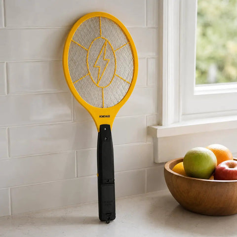 Powerful Handheld Bug Zapper For Home And Outdoors leaning against a tiled wall, showing electric mosquito killer racket with yellow frame and 3-layer grid.