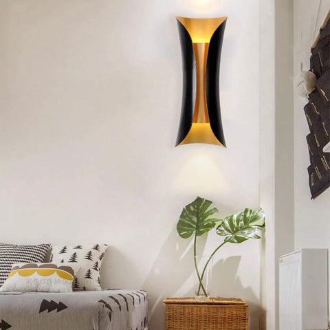 Modern Metal Curl Wall Sconce Indoor Lighting in bedroom, sleek black and gold design, ambient light showcasing decorative plant.