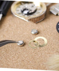 Gold 14 Piece DIY Clock Parts Kit For Metal Quartz Clock Repair Includes nuts, washers, tools on cork background