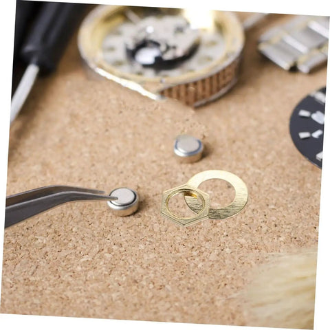 Gold 14 Piece DIY Clock Parts Kit For Metal Quartz Clock Repair Includes nuts, washers, tools on cork background