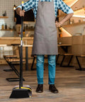 Heavy Duty Standing Broom And Dustpan Combo Set With Adjustable Long Handle in use by man wearing apron in cafe