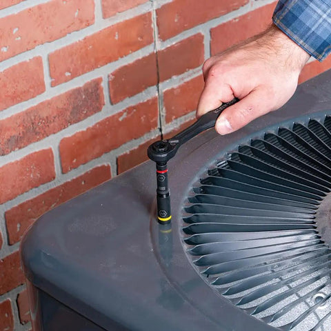 Using Impact Rated 46 Piece Multi Bit Screwdriver And Nut Driver Set to tighten a nut on an air conditioning unit outdoors.