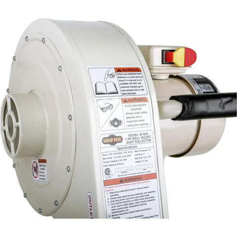 Close-up view of W1826 Wall Mounted Dust Collector with safety labels, 2.5 micron filtration, 1 HP motor, 4 inch intake, white finish.