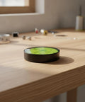 Qianly Bubble Level with Degree Markings Metal Circular Spirit Level Compact for Home Improvement Hobbyists, Turntable Alignment, Black Shell, Green Liquid, 60x12mm on wooden surface.
