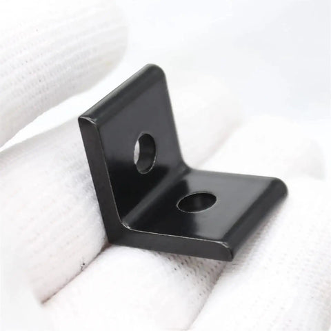 Check Out These 10 pcs Of Heavy Duty Aluminum Extrusion Profiles And Corner Brackets That Are Super Durable And Perfect For Any Wild Project or Cool Build. Black corner bracket held in hand on white background.