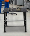 Built Like A Tank Heavy Duty Welding Table 36 By 24 Inches with steel top, clamps, and tools on a sturdy workbench.