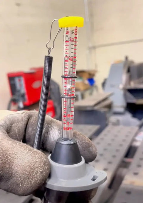 Gas Flow Meter For MIG TIG Welding With Pinpoint Accuracy And Easy Argon CO2 Compatibility User Friendly Interface And Pro Grade Quick Setup For Precise Gas Control Less Waste And Cleaner Welds In Your Projects. gas flow meter with clear tube, spring hook, and gray base for MIG/TIG gas control