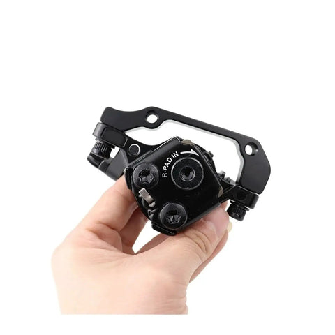 Mechanical disc brake caliper with resin pads held in hand, compatible for Shimano TX805 and M375 models, showcasing durable design.