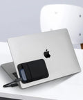 Two Pocket Portable SSD Sleeve For Laptops With Reusable Adhesive attached to a laptop, showing dual pockets and cable slot, black pouch.