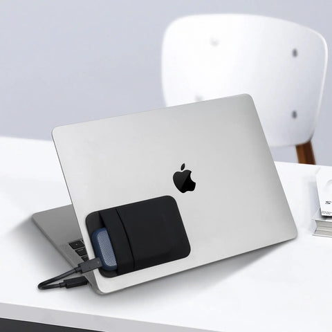 Two Pocket Portable SSD Sleeve For Laptops With Reusable Adhesive attached to a laptop, showing dual pockets and cable slot, black pouch.