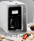 Fully Automatic Bean To Cup Coffee Maker With Built In Grinder Removable Reservoir And Smart Thermal Insulation on countertop with coffee and snacks.