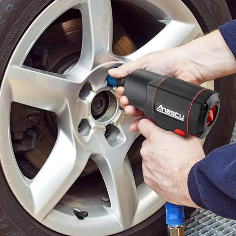 Person using Beast Of A Half-Inch Air Impact Wrench With Twin Hammer, 1700 Nm Max, on a car wheel with composite body and soft grip.