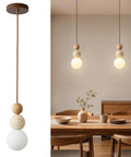 Wabi Sabi Travertine Pendant Light with Wood Ball & Milk Glass Shade over wooden dining table, showcasing natural stone and smooth glass.