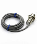 Compact Motion Sensor And Inductive Proximity Switch TR18-5AO For Precise Object Detection In Robotics, Automation, Industrial Equipment, And DIY Projects For Makers And Tech Enthusiasts. Gray threaded metal sensor with cable
