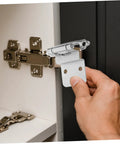 Cabilock silver soft-close inset cabinet hinge installed on white kitchen cabinet door.