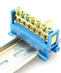 Seven Position Terminal Block Bus Bar With Brass Screw Terminals For DIN Rail Grounding Strip Easy Snap In Mount Fifty Millimeter Long Six Millimeter Holes M5 Screws Copper Bar Height Nine Millimeter Bottom Mount Cold Pressed Copper, plastic insulator visible
