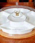 White ceramic serving tray with crystal glass knob handle on wooden table, showcasing elegant design.