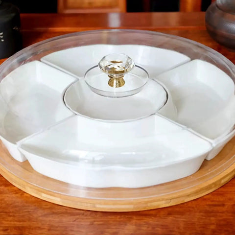 White ceramic serving tray with crystal glass knob handle on wooden table, showcasing elegant design.