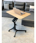 Hella Stable Mobile Standing Desk Featuring Instant Gas Spring Lift And Smooth Glide Rollers For A Total Game Changer Home Office Upgrade Or Flexible Workspace Setup In Clean Black with laptop on wooden top.