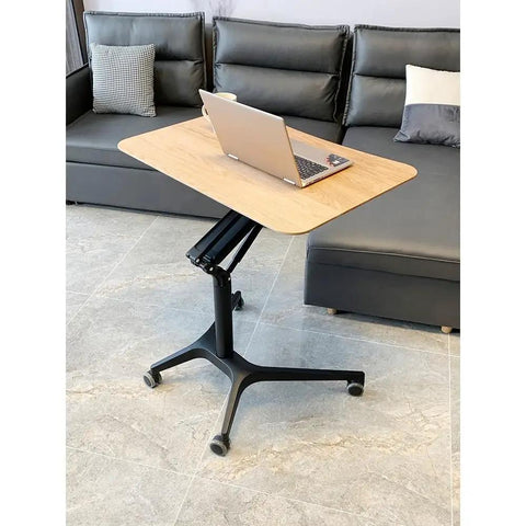 Hella Stable Mobile Standing Desk Featuring Instant Gas Spring Lift And Smooth Glide Rollers For A Total Game Changer Home Office Upgrade Or Flexible Workspace Setup In Clean Black with laptop on wooden top.