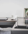 7 Ball Desk Pendulum Cradle with Glass Base and Stainless Steel Balls on an office desk setup